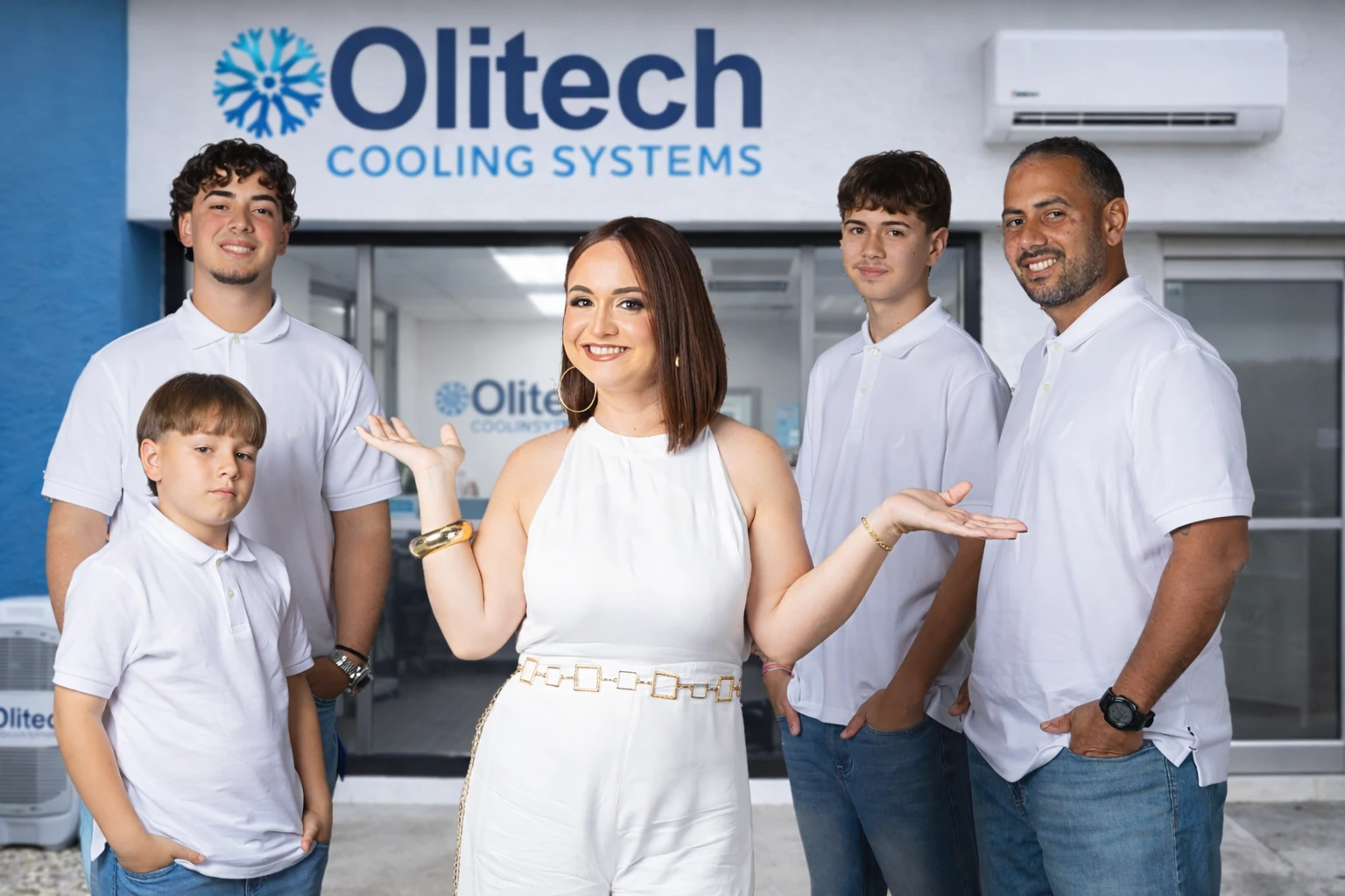 Family HVAC team standing outside with a mini split air conditioner, representing Olitech Cooling Systems.