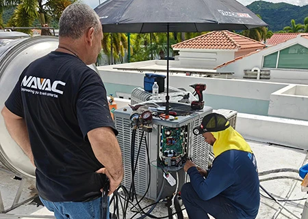 Olitech Cooling Systems team repairing an air conditioning unit on a residential rooftop in Puerto Rico